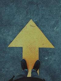 person standing on a yellow arrow