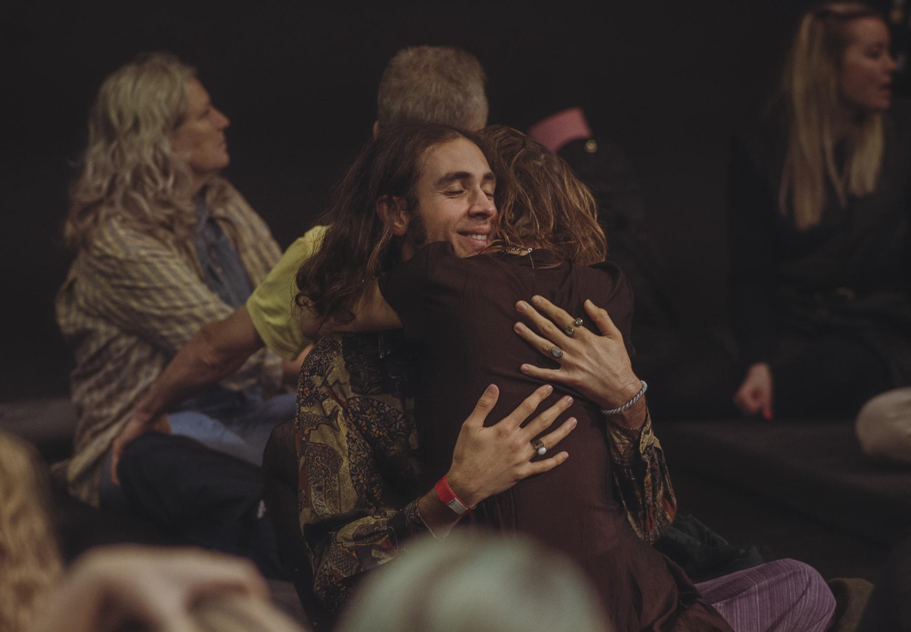 Two participants sharing a warm hug in the circle at Copenhagen Tantra Festival