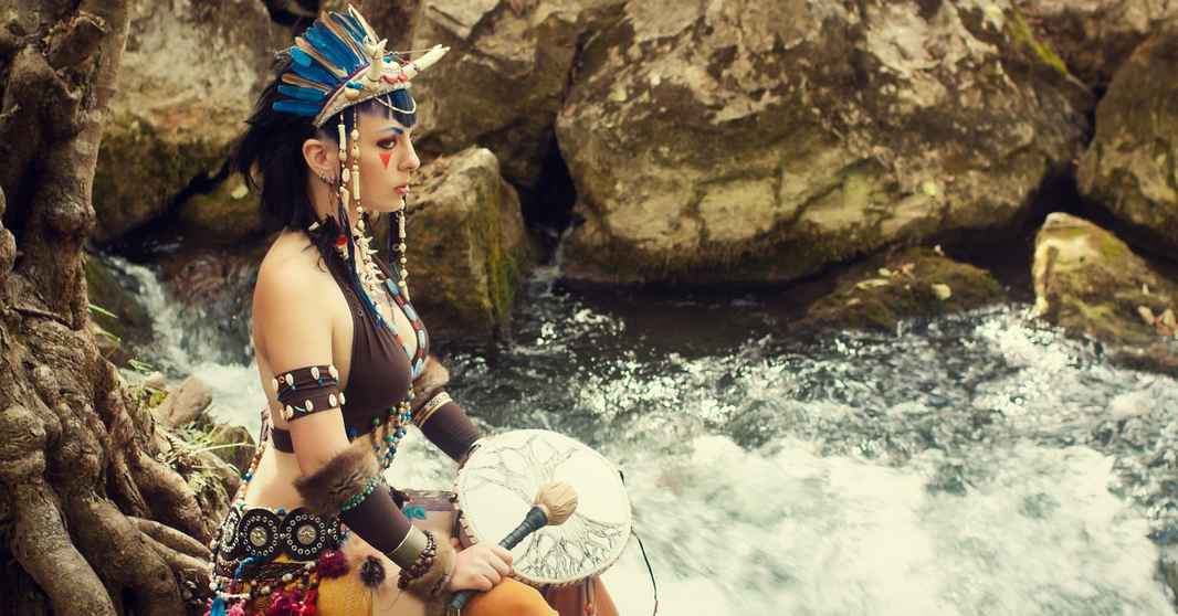2025-shaman-kvinde-ved-vandfald-med-tromme-1200x628
