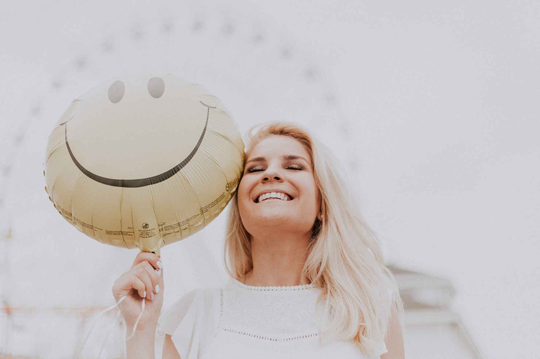 Canva - Woman Holding a Smiley Balloon