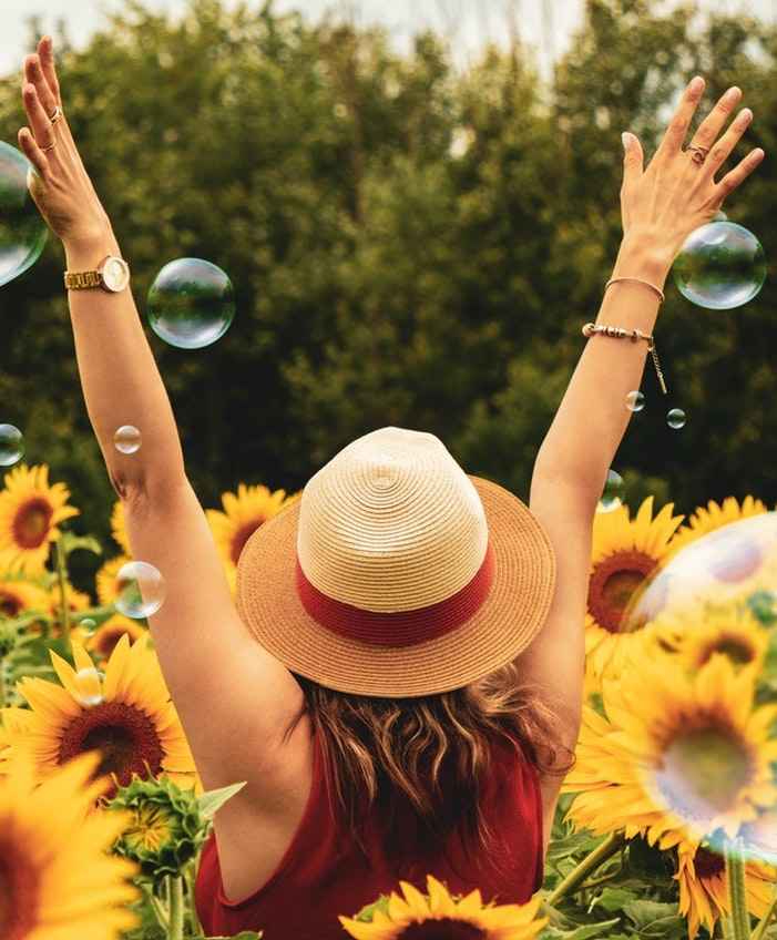 kvinde glad menstruationscyklus solsikke Laura Grubb fire faser lev efter din cyklus harmoni glæde