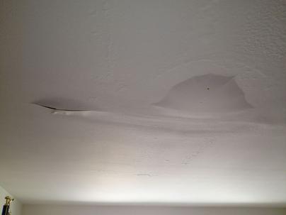 Et hvidt loft, hvor der er en vandskade