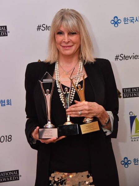 En blond kvinde som står med nogle awards i favnen som hun har vundet