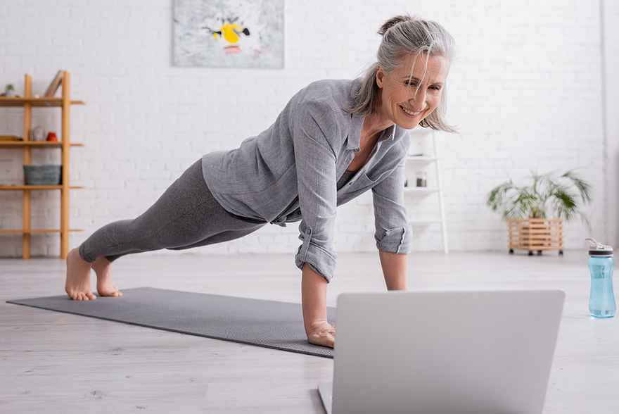 mature woman practicing yoga at home