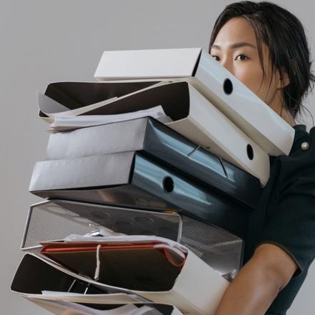 asiatisk kvinde som har en høj stabel mapper