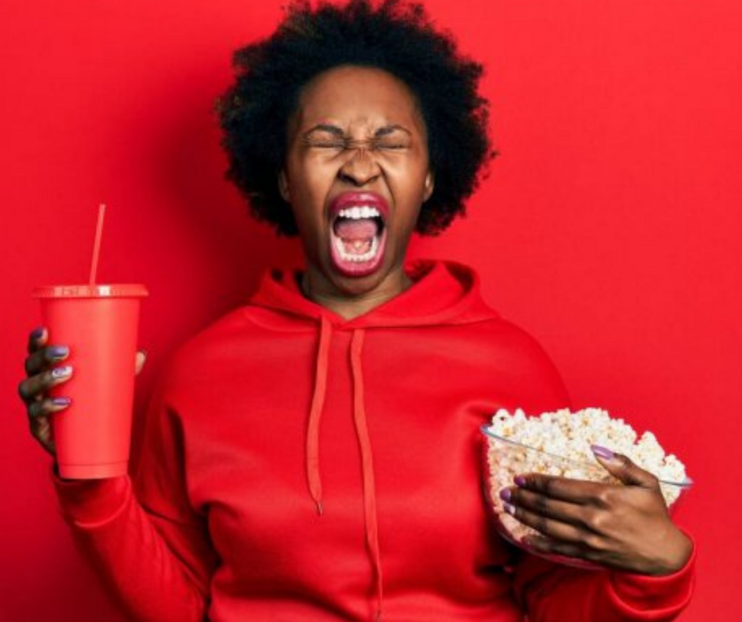 Woman in red yelling with popcorn