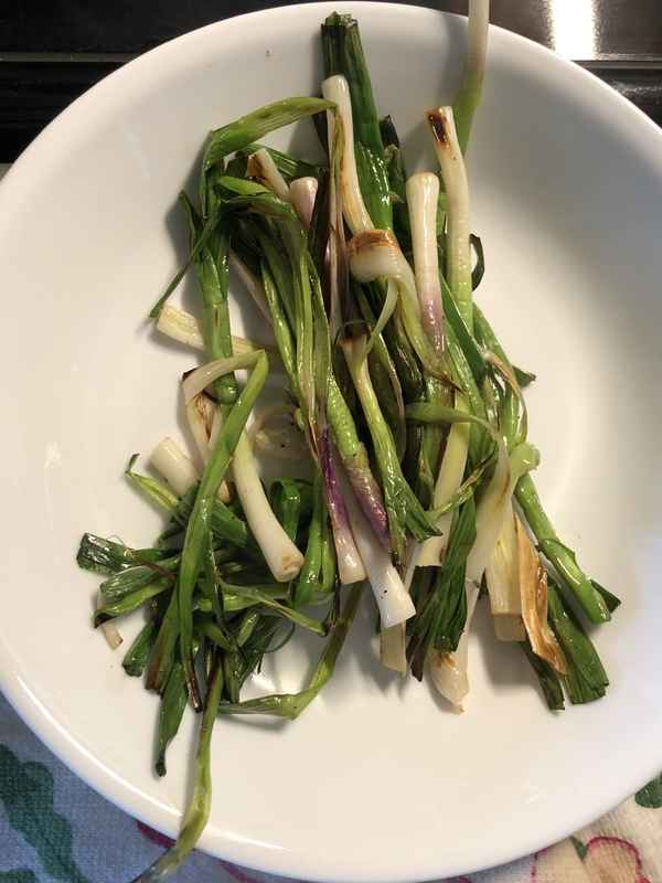 cooked spring garlic on a plate