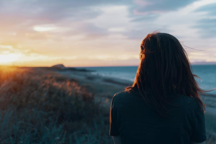 woman-on-shoreline-gazing-at-sunset