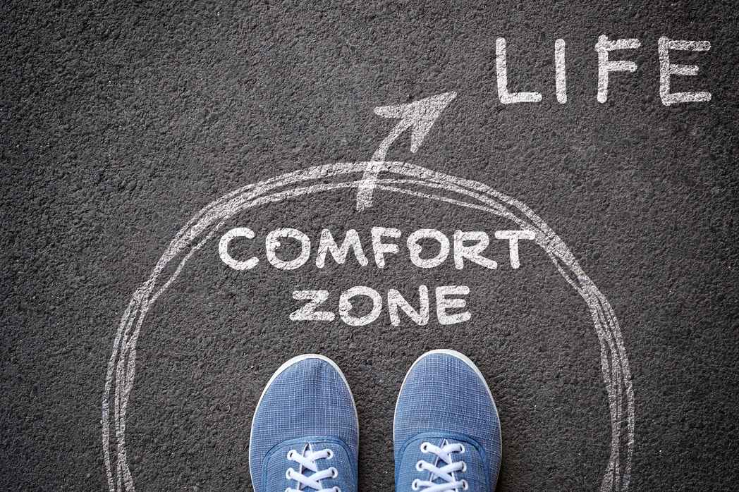 exit-from-comfort-zone-concept-feet-blue-jeans-sneakers-standing-inside-circle-comfort-zone-outward-arrow-chalky-asphalt