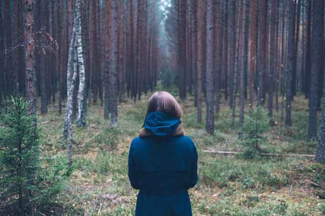 woman standing in forest