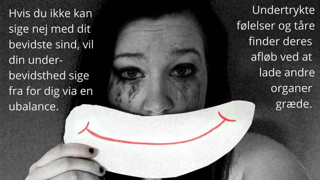 Kvinde som har grædt viser et falsk smil
