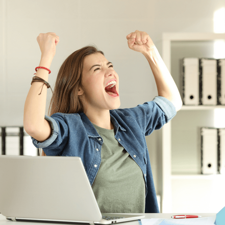 En kvinde der har armene over hovedet fordi hun har fået en god besked