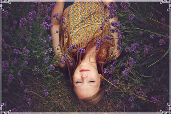 lady lying in field of flowers