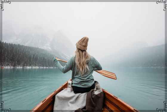 Woman paddling on boat in the winter