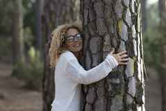SImona Pilolla krammer træ og smiler med lukkede øjne
