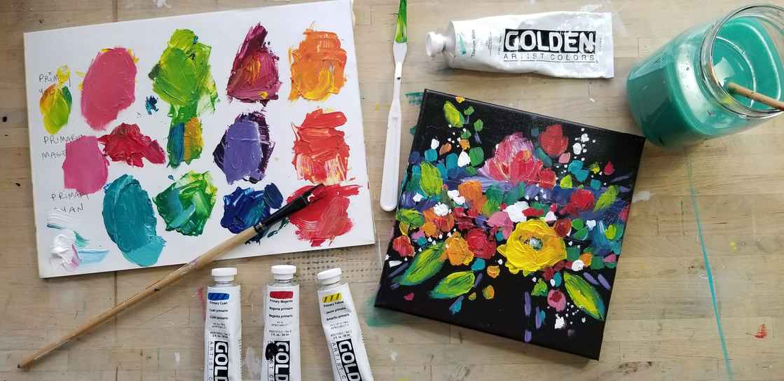 12 Mixed colors on a paper with paint tubes on the side and a glass of paint water.