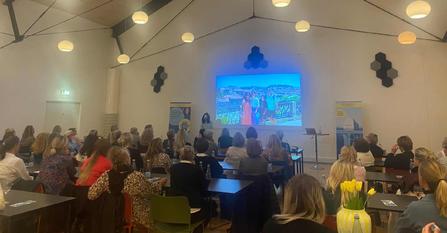 En sal fuld af tilskuere til et foredrag