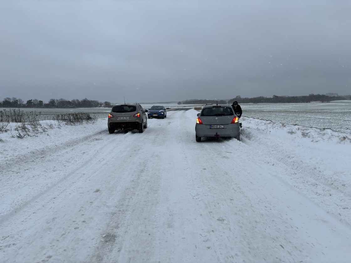 Biler holder på landevej med sne