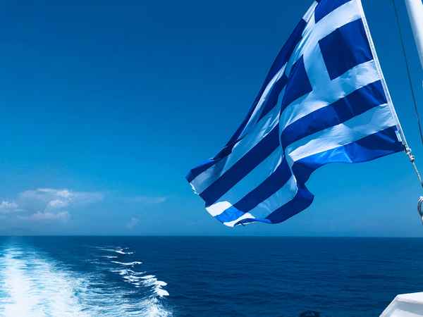 Luxury Charter Trip showing Blue Sea of Greece and Greece's Flag